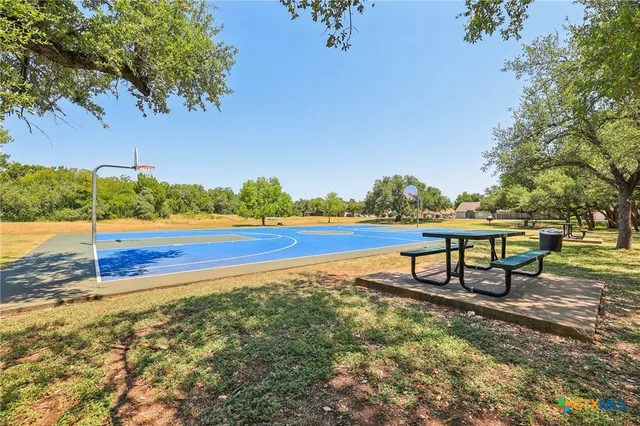 a view of a lake with a bench and trees around
