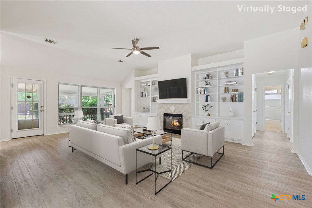 303 North Kings Canyon Drive Cedar Park, TX 78613 - Photo 3 of 24 a living room with furniture a fireplace a flat screen tv and a large window