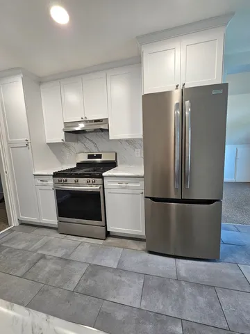 a kitchen with a stove a refrigerator and a cabinets