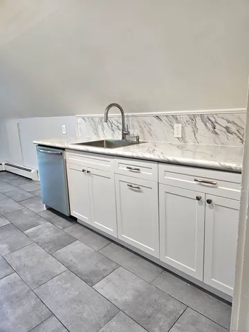 a sink with white cabinets