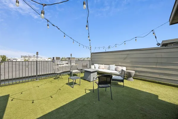 a roof deck with table and chairs and wooden floor