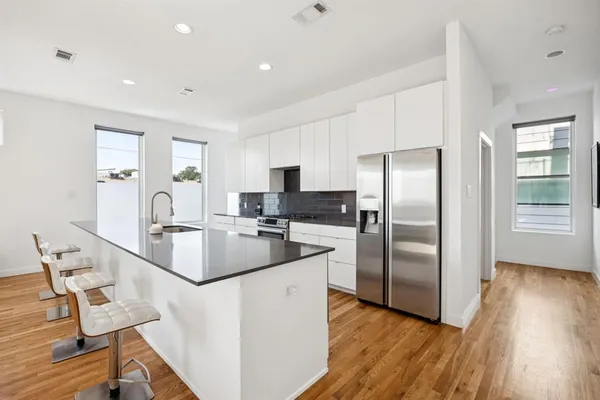 a large kitchen with kitchen island a large counter top space a sink stainless steel appliances and cabinets