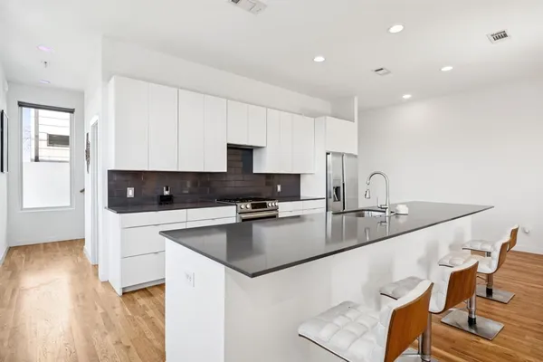 a kitchen with stainless steel appliances granite countertop a sink a stove a microwave a counter top space and cabinets