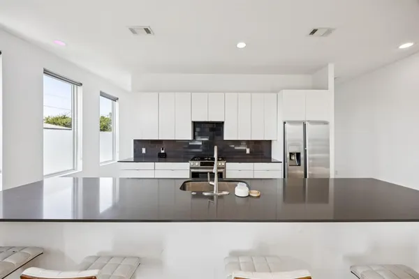 a kitchen with kitchen island a stove a sink and a refrigerator