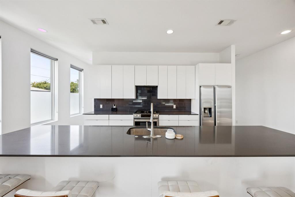 4903 Jack Court Dallas, TX 75206 - Photo 7 of 26 a kitchen with kitchen island a stove a sink and a refrigerator