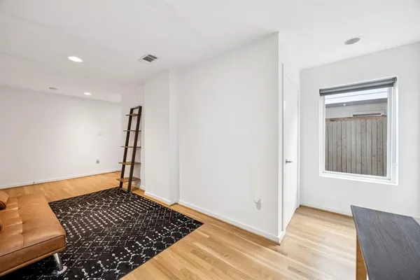 a view of a room with wooden floor and a rug