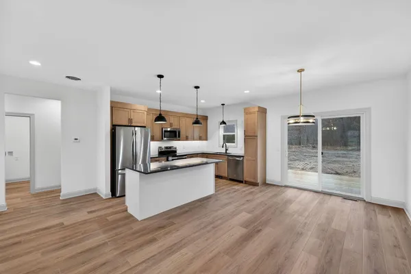 a kitchen with stainless steel appliances granite countertop a refrigerator a stove a sink and a refrigerator