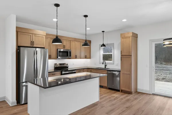 a kitchen with stainless steel appliances granite countertop a refrigerator a oven and a sink