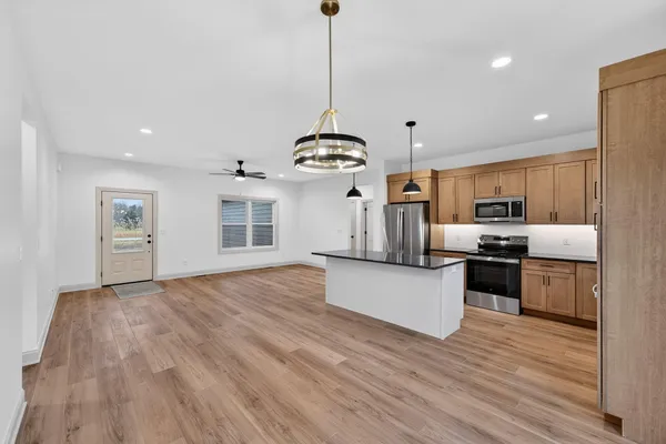 a kitchen with stainless steel appliances granite countertop a sink a stove and a refrigerator