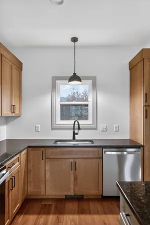 an empty room with wooden floor chandelier fan and windows