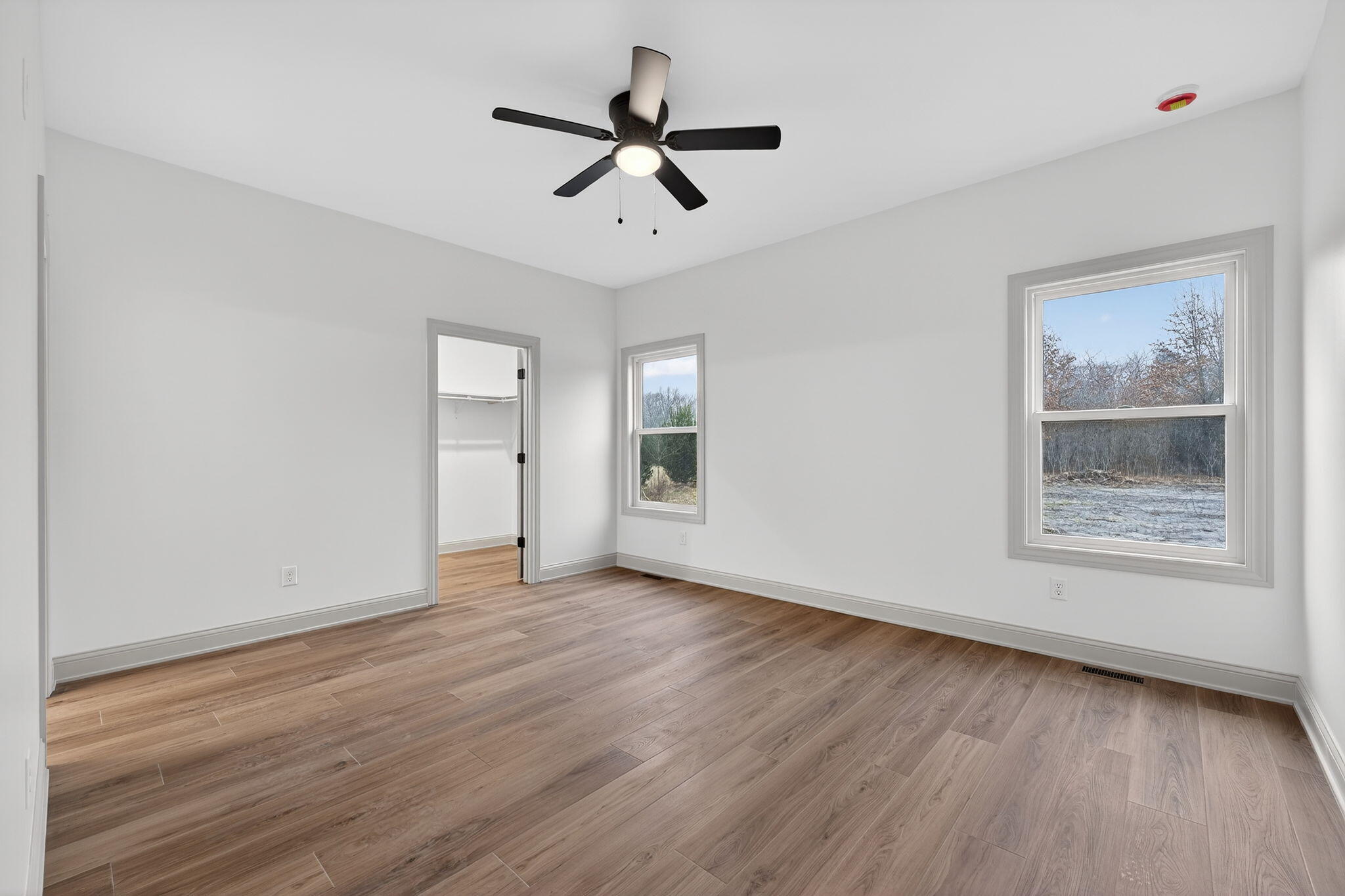 238 East 550 North Rensselaer, IN 47978 - Photo 22 of 35 an empty room with wooden floor chandelier fan and windows