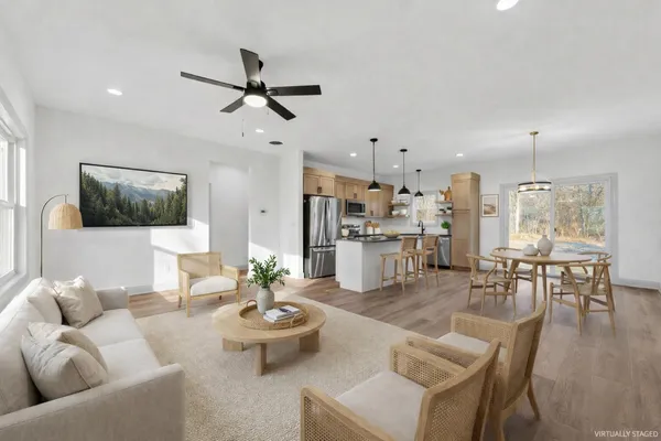 a kitchen with kitchen island a counter top space wooden floor and a refrigerator