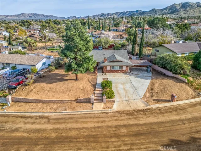 an aerial view of residential houses with outdoor space and trees