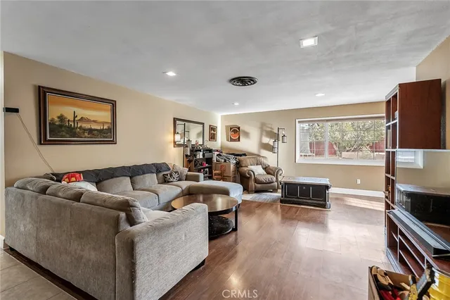 a living room with furniture and a flat screen tv with wooden floor