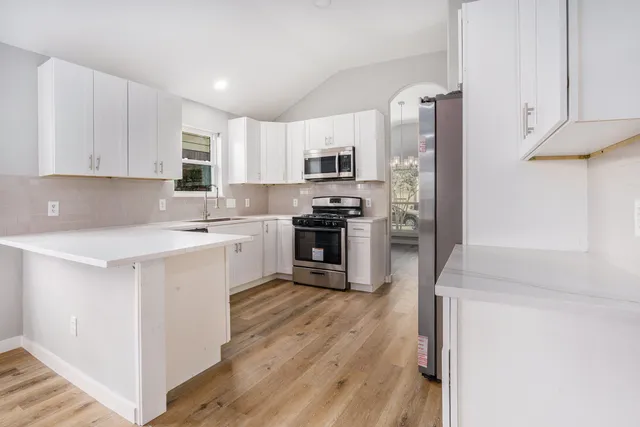 a kitchen with cabinets stainless steel appliances a sink and a stove