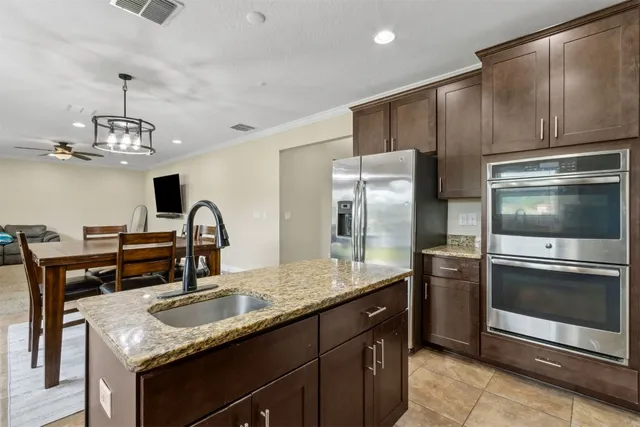 a kitchen with granite countertop white cabinets sink and stainless steel appliances