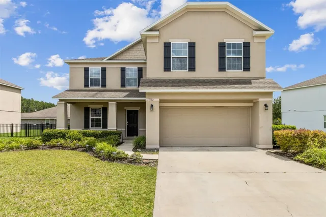 a front view of a house with a yard and garage