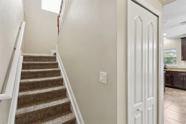 a view of an empty room with wooden floor and windows