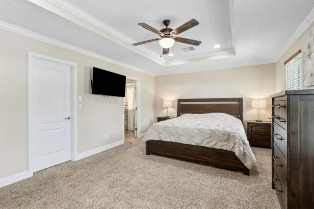 a bedroom with a bed and a flat tv screen on dresser
