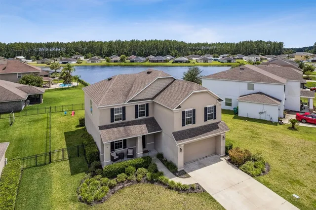 an aerial view of a residential houses with yard