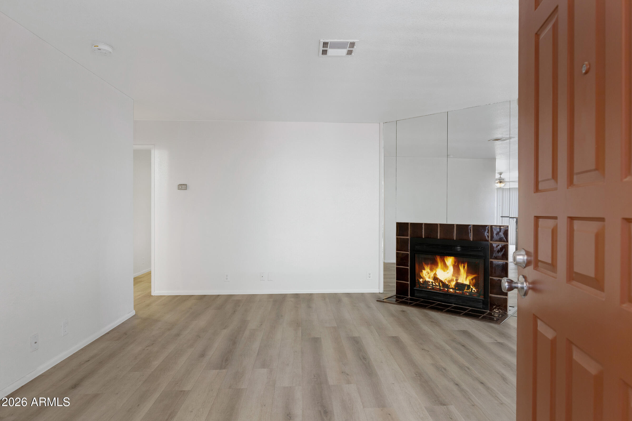 20235 North 3rd Drive, Unit 8 Phoenix, AZ 85027 - Photo 2 of 30 a view of an empty room with a fireplace and wooden floor