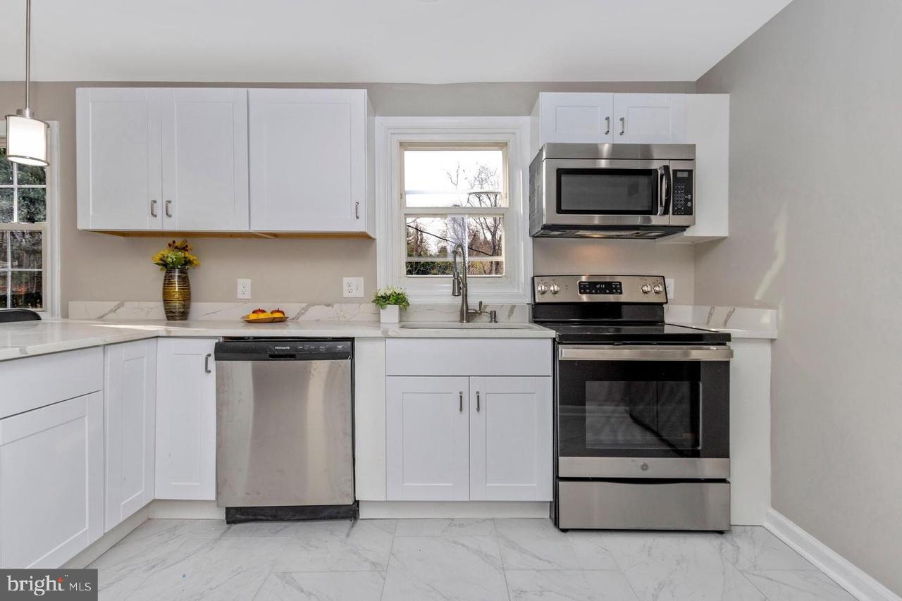 6738 Allview Drive Columbia, MD 21046 - Photo 12 of 33 a kitchen with white cabinets and stainless steel appliances