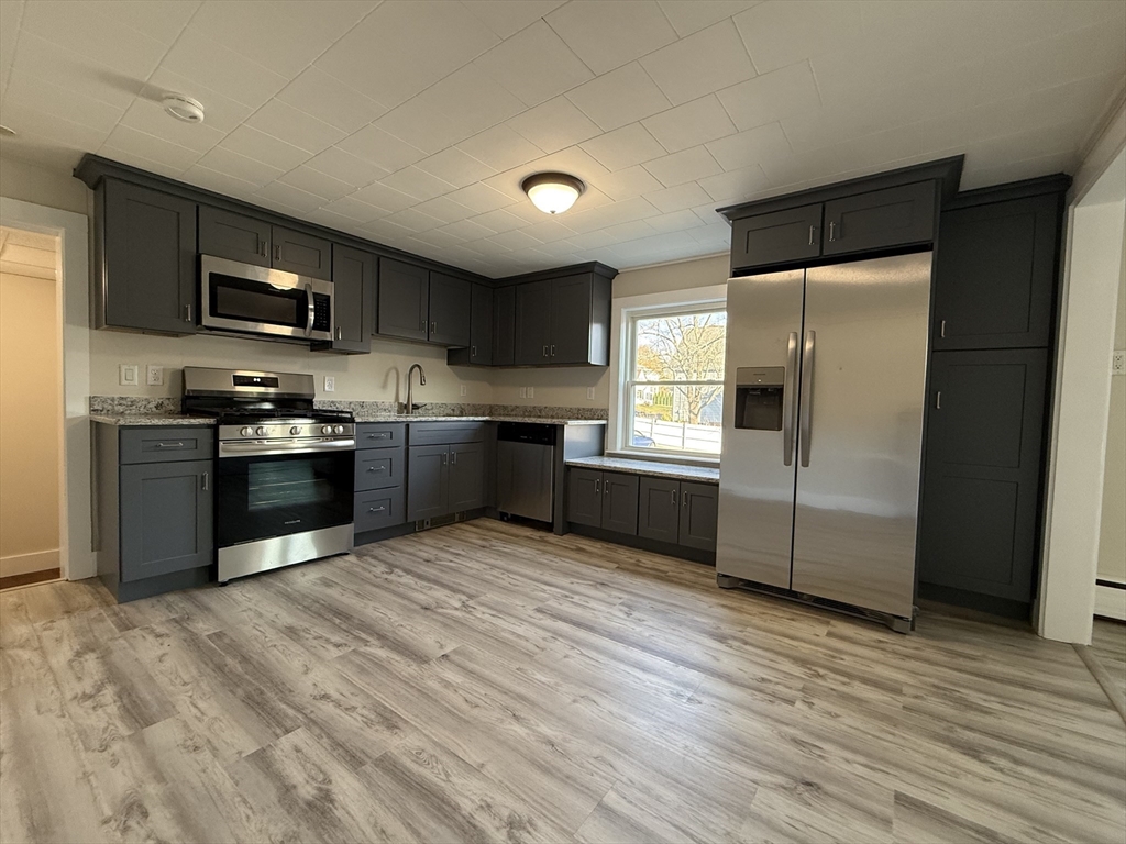 866 Center Street, Unit 2 Middleboro, MA 02346 - Photo 3 of 11 a large kitchen with stainless steel appliances granite countertop a stove a sink and a refrigerator