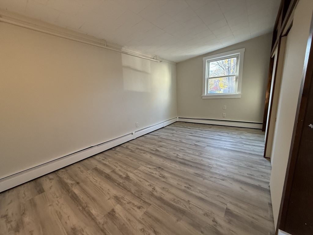 866 Center Street, Unit 2 Middleboro, MA 02346 - Photo 9 of 11 a view of an empty room with wooden floor and a window