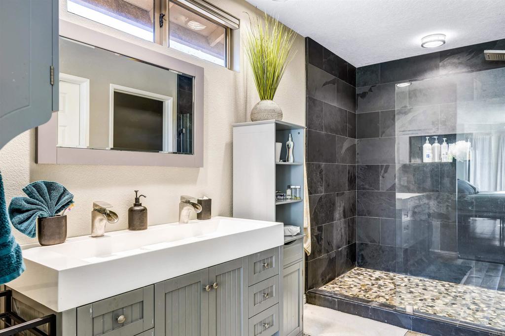 4559 Coronado Drive Oceanside, CA 92057 - Photo 15 of 29 a bathroom with a sink a mirror and a shower