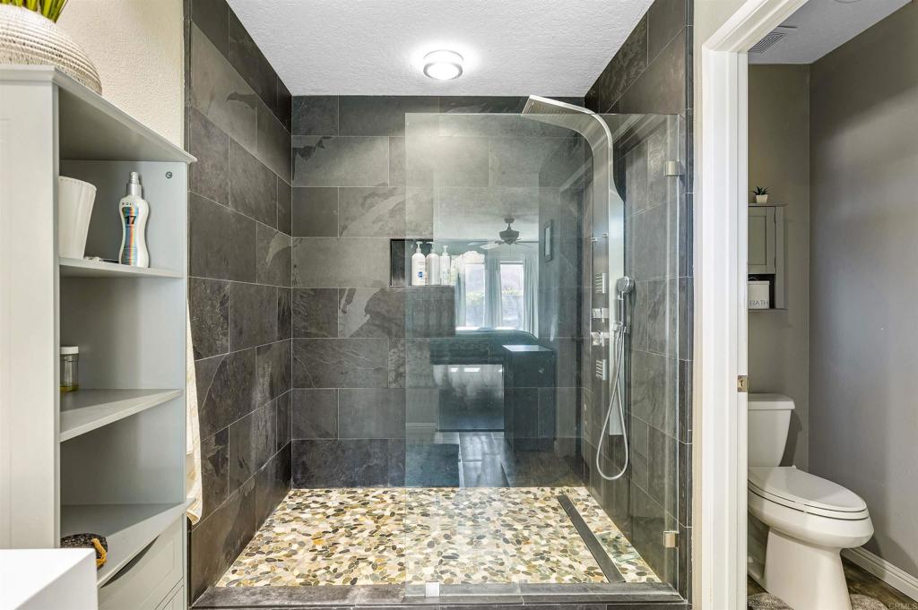 4559 Coronado Drive Oceanside, CA 92057 - Photo 18 of 29 a bathroom with a glass door shower and a toilet