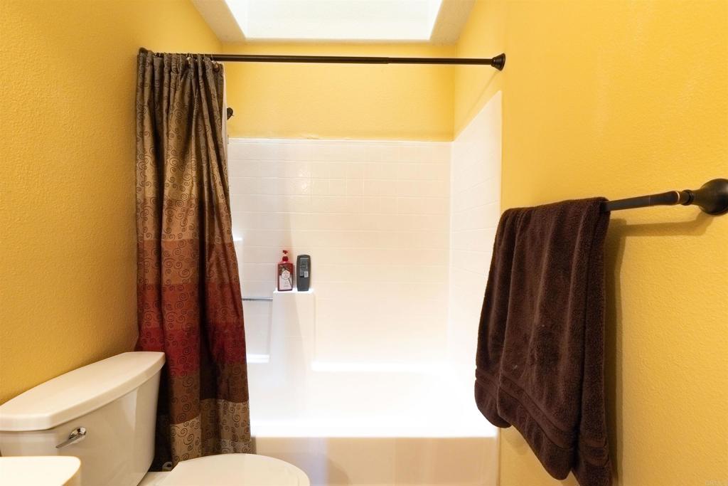 4559 Coronado Drive Oceanside, CA 92057 - Photo 22 of 29 a bathroom with a toilet and a shower curtain