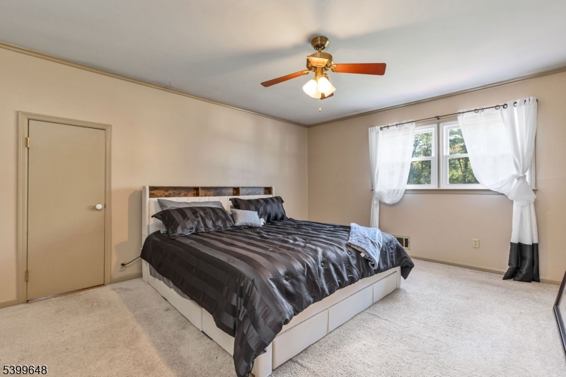 512 Township Line Road Hillsborough, NJ 08844 - Photo 21 of 40 a bedroom with a large bed and a chandelier