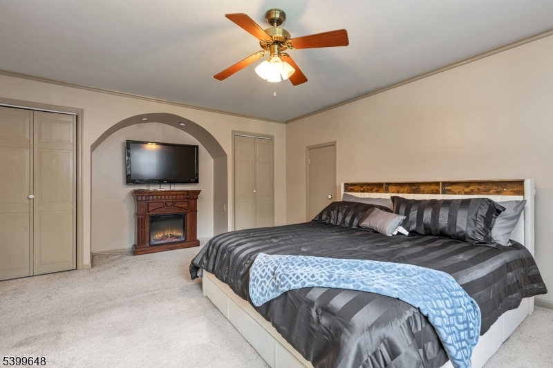 512 Township Line Road Hillsborough, NJ 08844 - Photo 22 of 40 a bedroom with a large bed and a fireplace