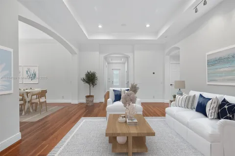 a living room with furniture a flat screen tv and a large window