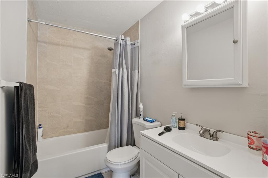 11580 Dean Street, Unit 582 Bonita Springs, FL 34135 - Photo 19 of 22 Full bathroom featuring toilet, shower / bath combination with curtain, and vanity