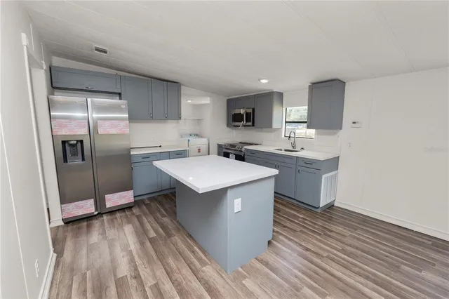 a view of a kitchen with a sink and wooden floor