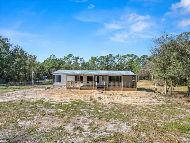 a view of a house with pool and a yard