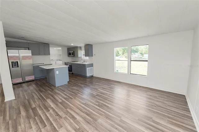 a living room with a sink cabinets and wooden floor