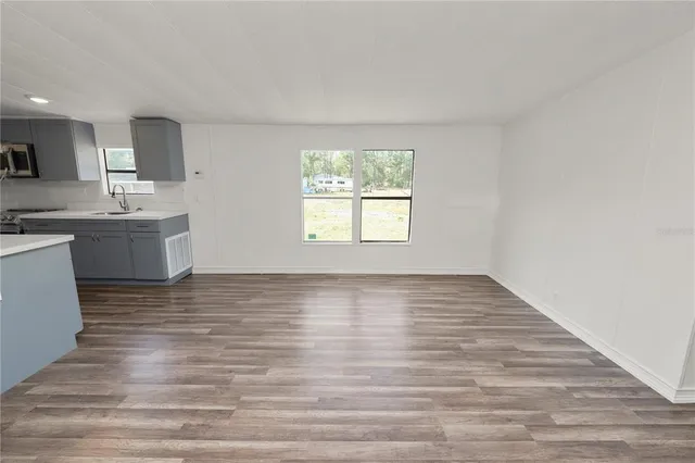 a view of kitchen and hall with wooden floor