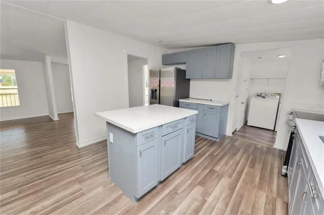 a kitchen with a sink a refrigerator and wooden floor