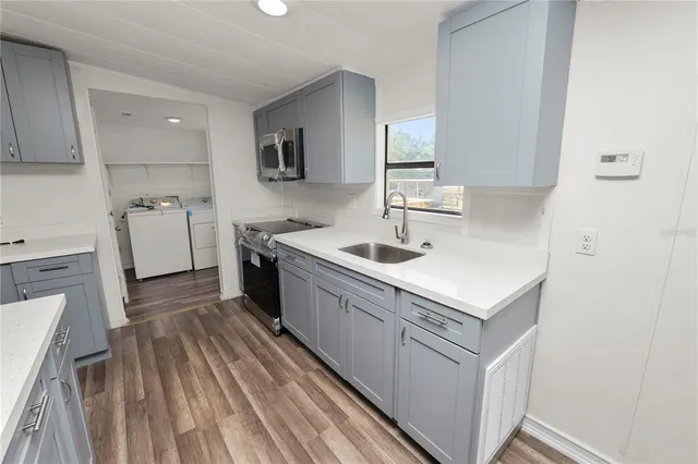 a kitchen with a sink refrigerator and cabinets