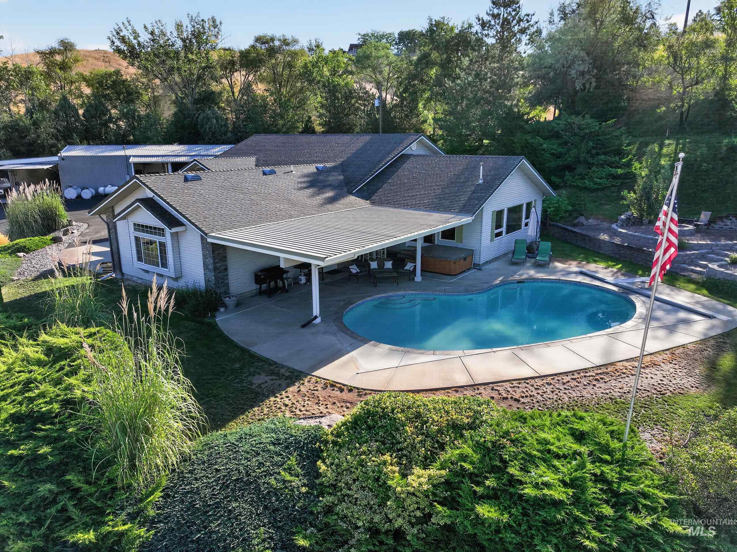5540 Finley Road Fruitland, ID 83619 - Photo 1 of 50 Exterior featuring a swimming pool, covered patio, hot tub, and stone accents