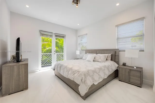a bedroom with a bed flat screen tv and window