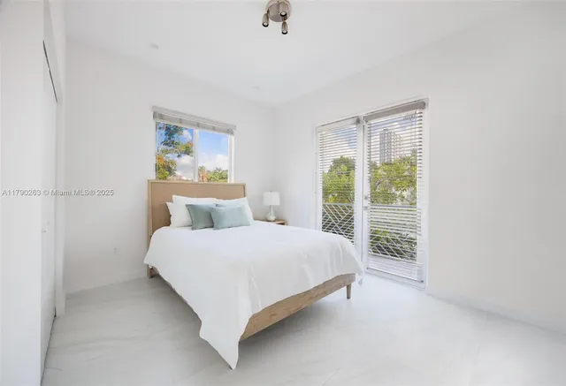 a large bed sitting in a bedroom next to a window