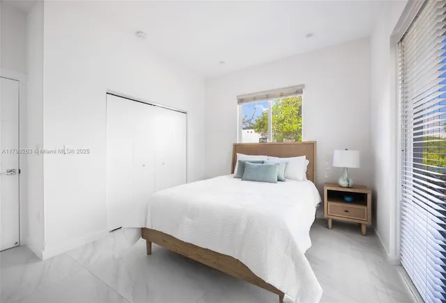 a bedroom with a bed and a window