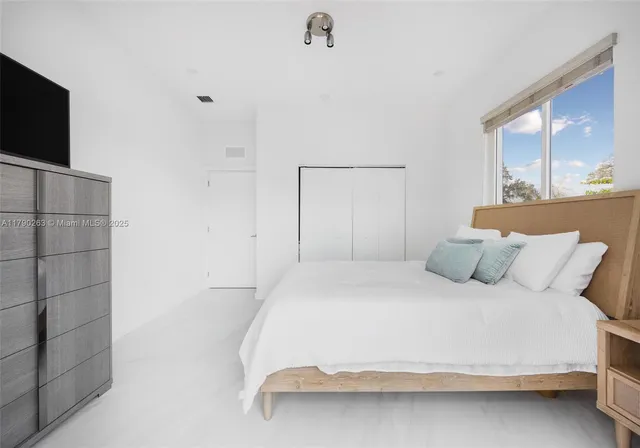 a bedroom with a bed and a flat screen tv