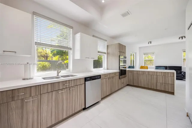 a large kitchen with a large window and white cabinets