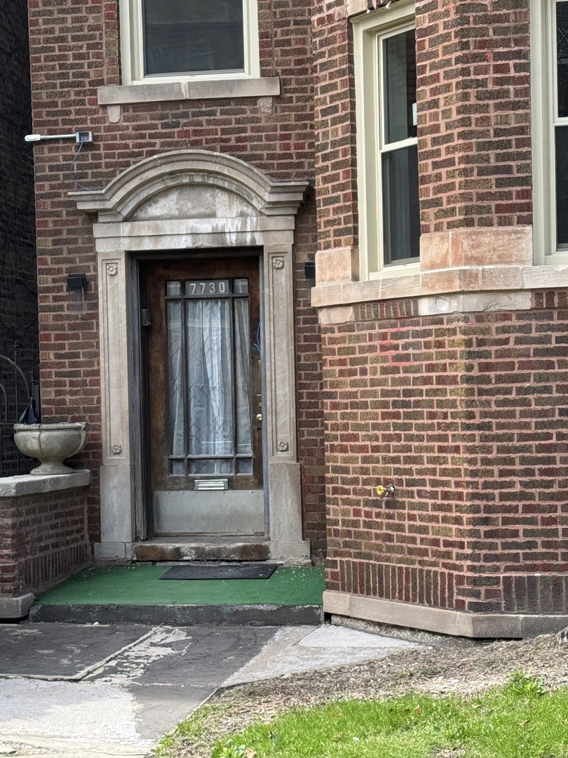 7730 South Cornell Avenue, Unit 3 Chicago, IL 60649 - Photo 1 of 1 a front view of a house with a garden