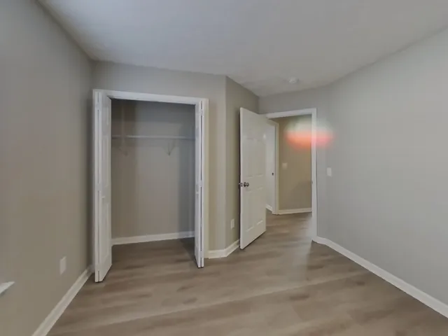 an empty room with closet and mirror
