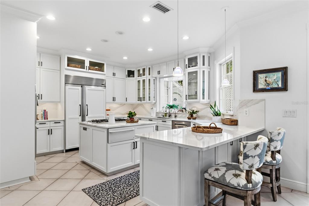 5382 Sandhamn Place Longboat Key, FL 34228 - Photo 15 of 55 a kitchen with stainless steel appliances kitchen island granite countertop a sink and cabinets